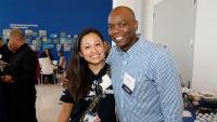 Two alumni smile together at alumni event.
